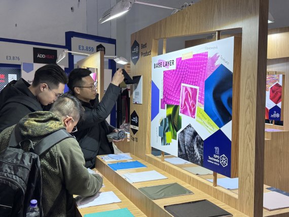 La gente se interesa por las tendencias textiles en ISPO Beijing 2024.