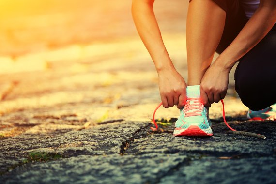 Frau bindet Schleife im Laufschuh