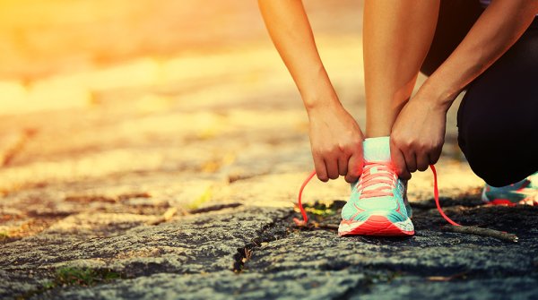 Frau bindet Schleife im Laufschuh