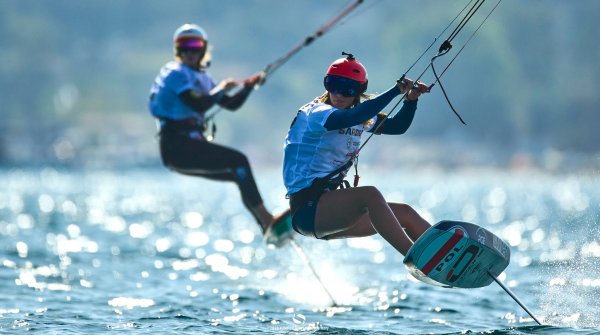 Two kitefoilers float over the water. 